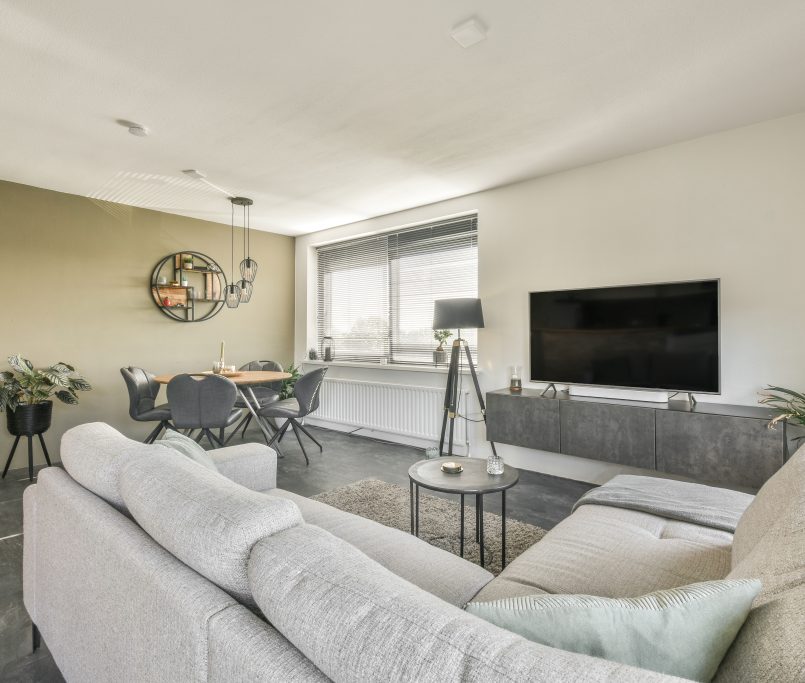 Luxurious living room in gray tones with a soft sofa and a round table